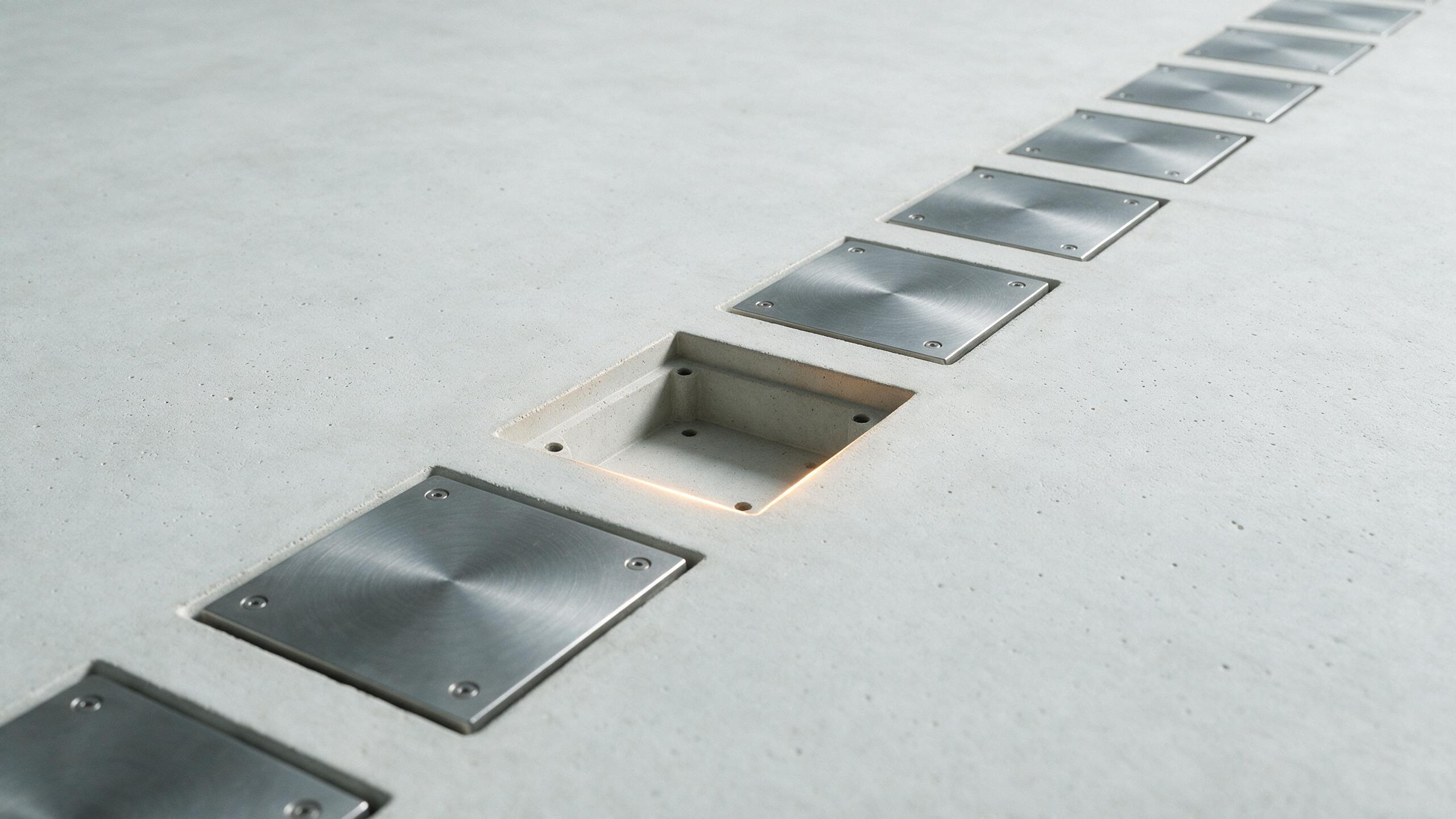 A row of recessed sockets each holding a fitted machined steel plate, with one correctly dimensioned socket left empty and its mounting holes unused
